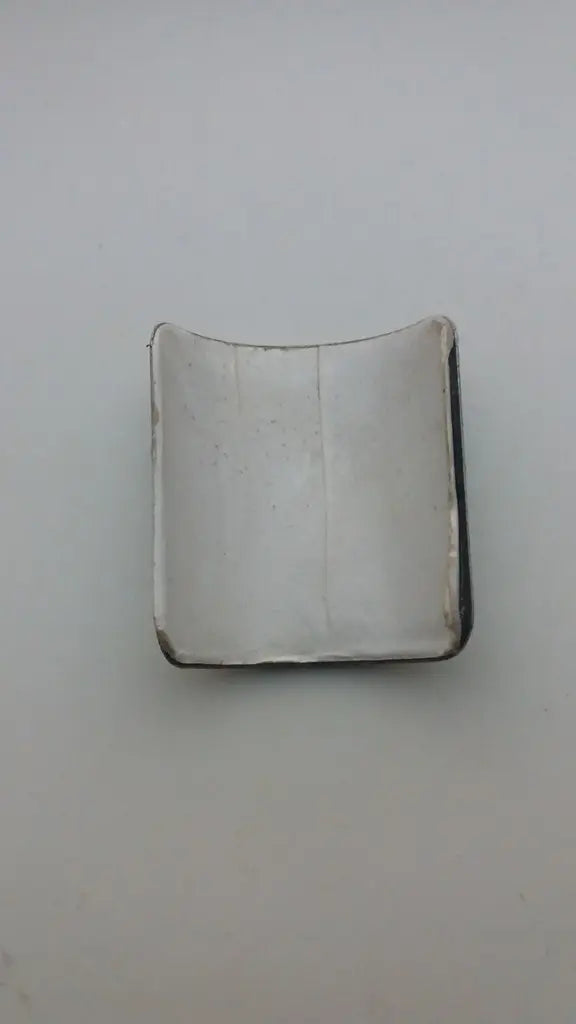 Rear view showing the pre-applied double-sided adhesive tape on the NOS Marin aluminum badge.