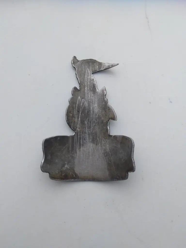 Rear view showing the clean adhesive-free metal backing on the Raleigh bike badge.
