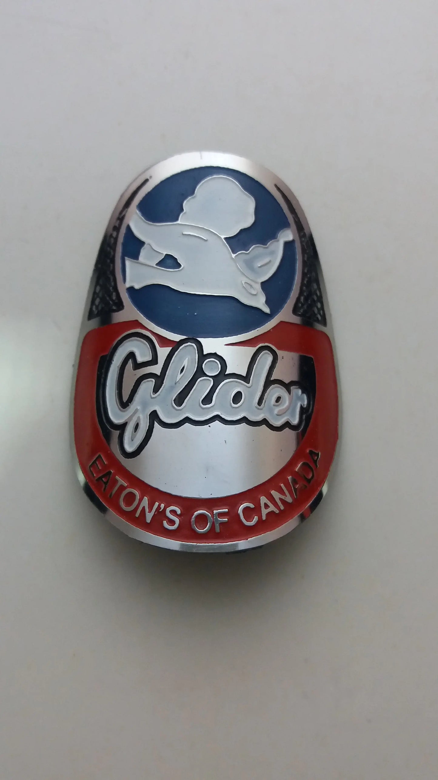 Metallic badge with 'Glider' branding on a light gray background