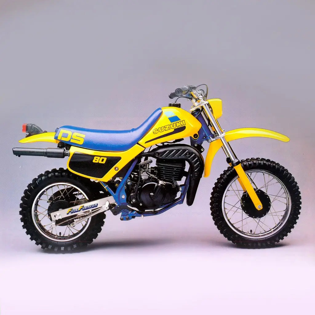 Yellow and blue Suzuki DS 80 1984 motorcycle on a gray background