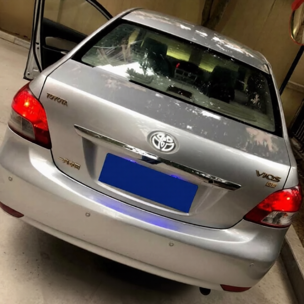 Rear Emblem White LED Toyota Vios sedan parked indoors, with the driver-side door open