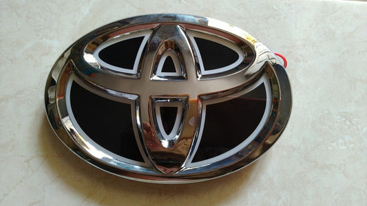 A close-up of the 5D light-up Toyota logo showing the premium chrome finish when the LEDs are turned off
