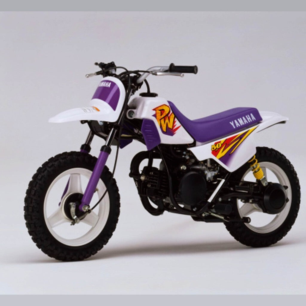 Small motorcycle Yamaha PW 50 with purple and white color scheme on a light gray background