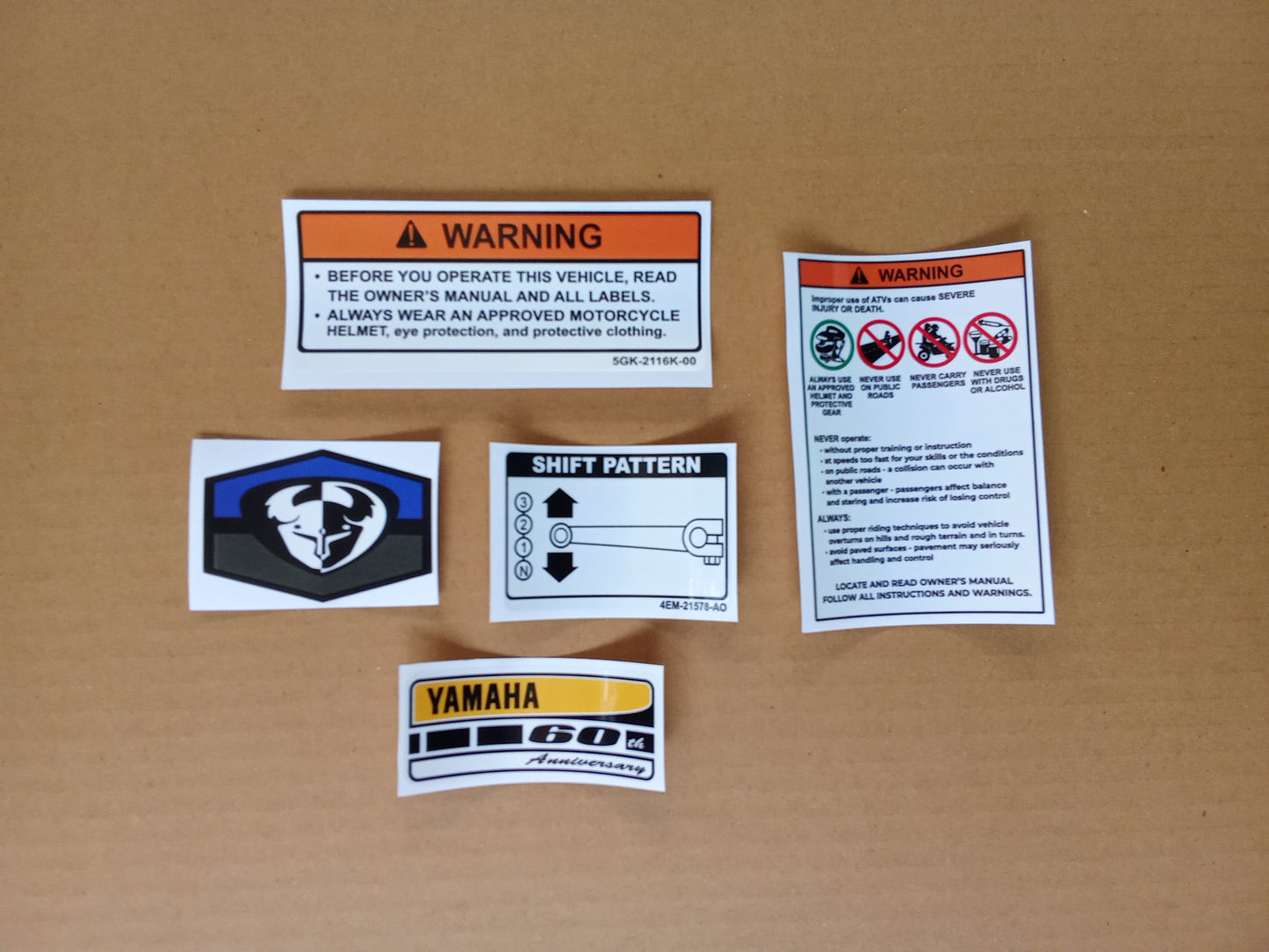 Set warning stickers of Yamaha PW 50 motorcycle stickers on a cardboard background