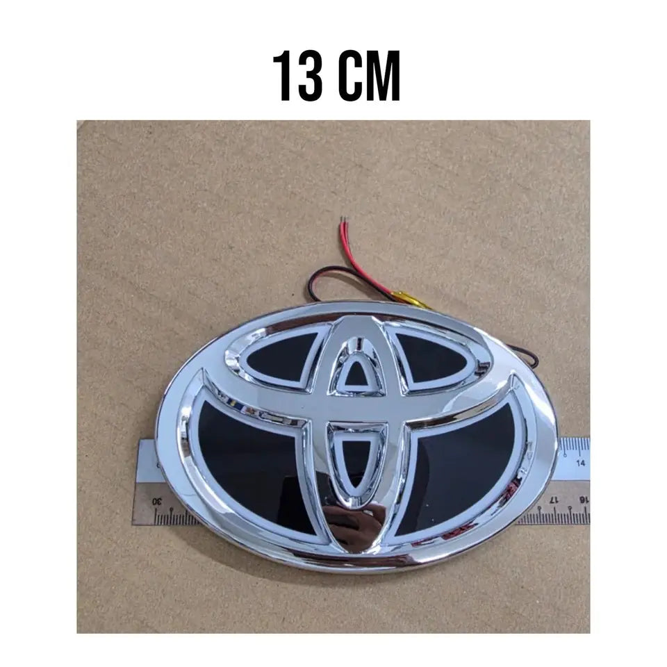 Installed view of the blue LED Toyota emblem glowing flush on a car rear tailgate.