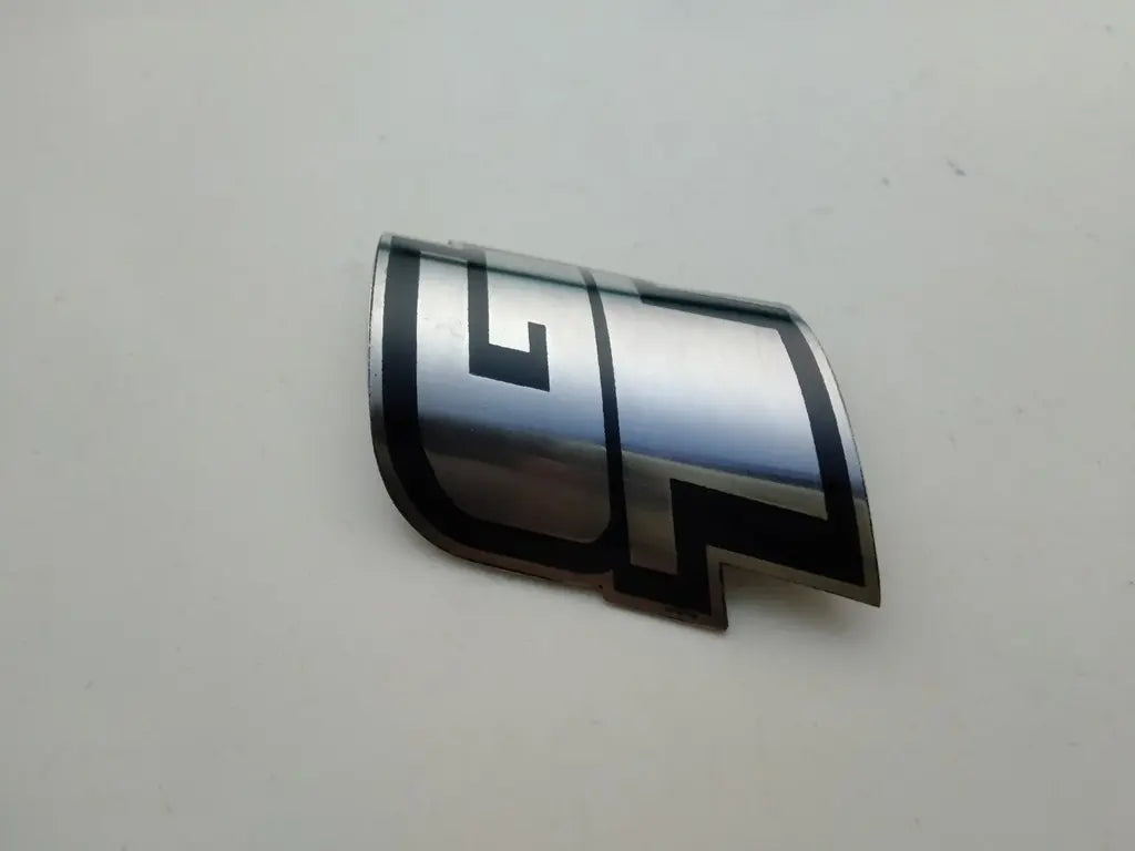 Close-up view of the detailed silver and black enamel crest on the GT steel head badge.