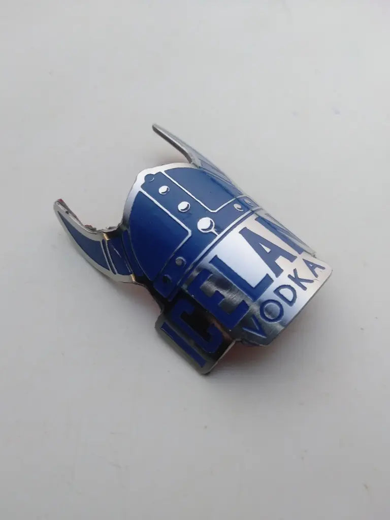 Side profile perspective showing the slim etched stainless steel construction of the Iceland emblem.