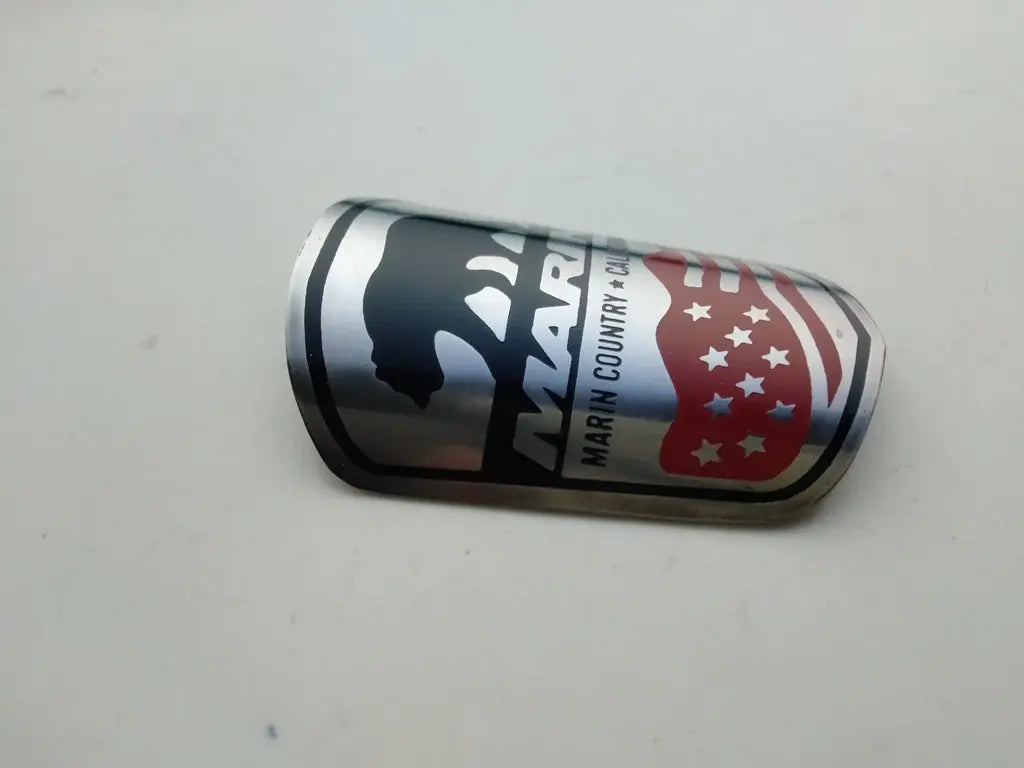 Close-up view of the detailed silver and black enamel logo on the Marin steel head badge.