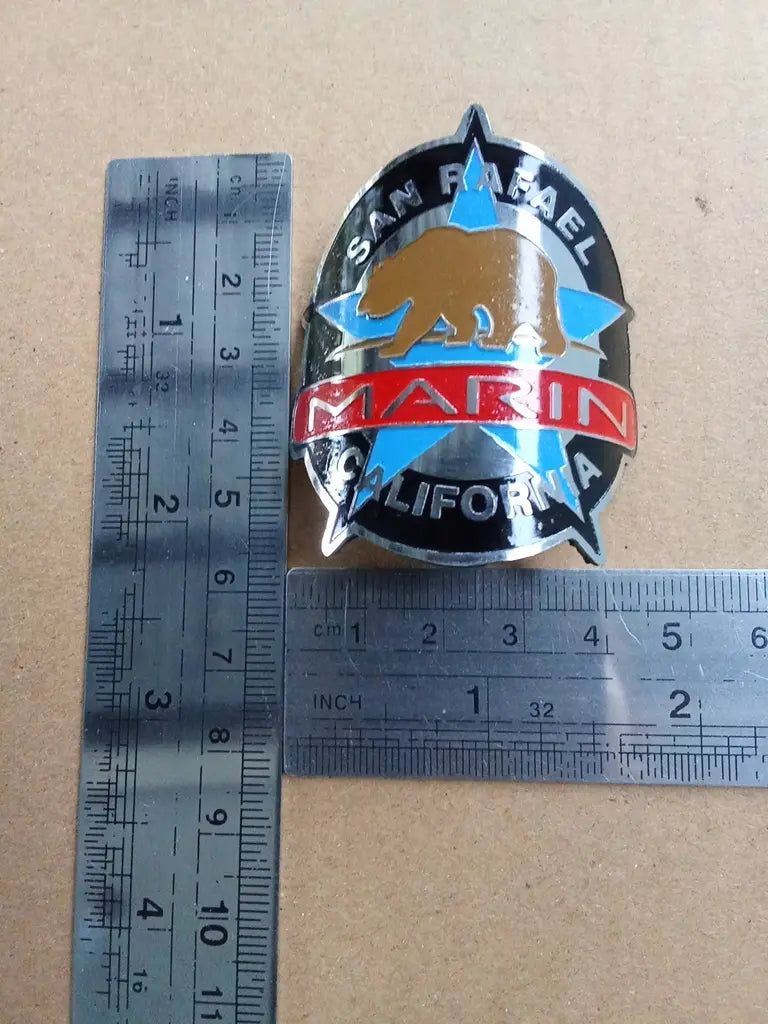 Measurement guide showing height and width dimensions of the handmade Marin San Rafael stainless emblem.