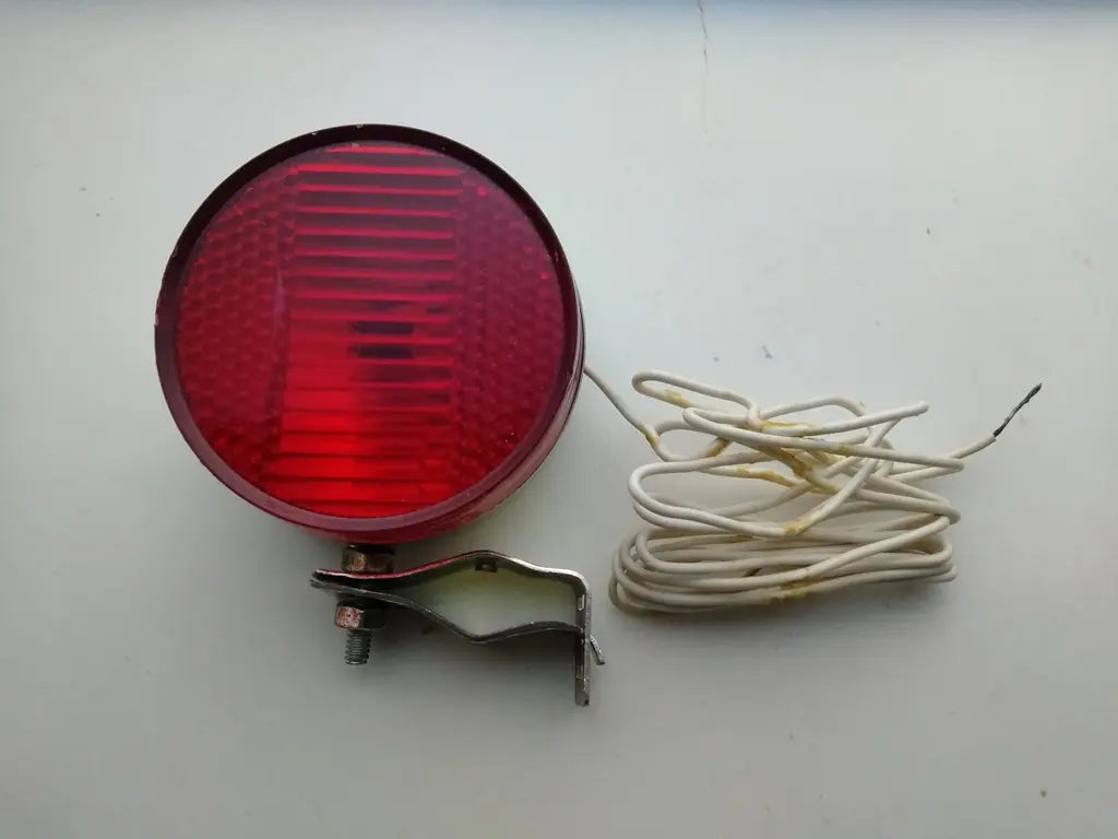 Detailed view of the metal frame clamp on the NOS bicycle safety light for universal bike mounting.