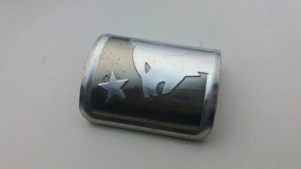 Close-up view of the detailed 3D embossed silver Marin Bear and star crest logo.
