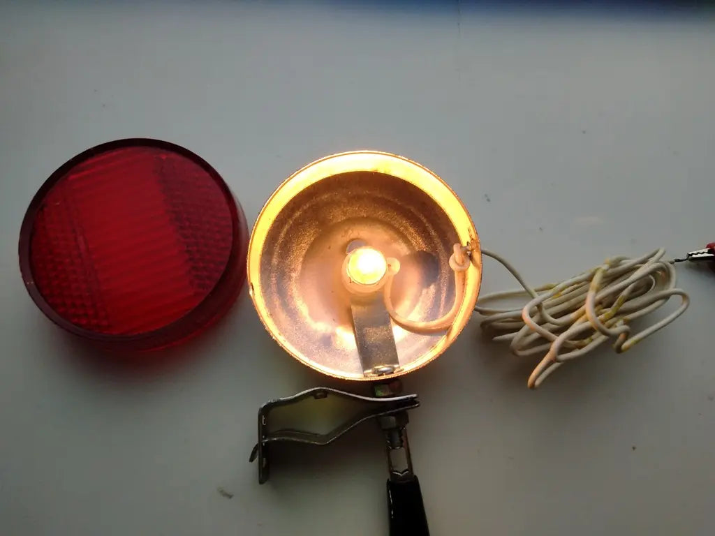 Close-up view of the working 2.5V 0.3A light bulb inside the vintage bicycle reflector housing.