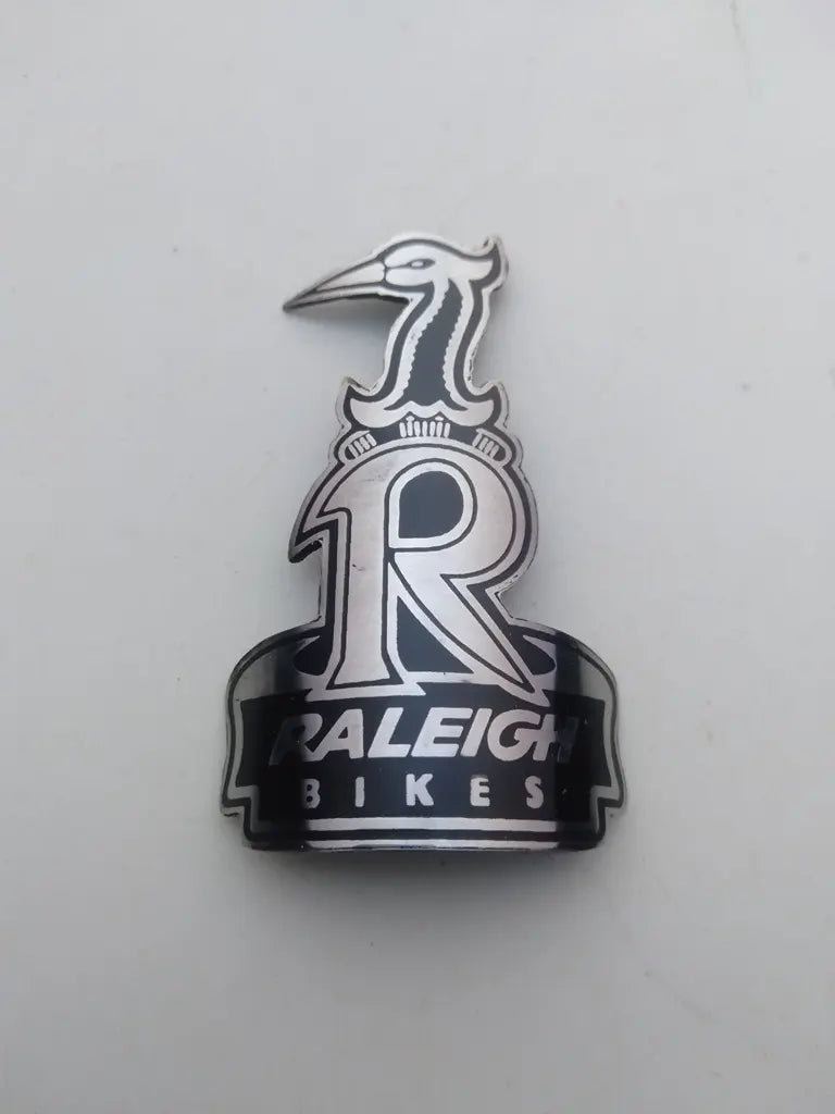 Raleigh bicycle head badge emblem in etched handmade stainless steel with silver and black Heron logo.