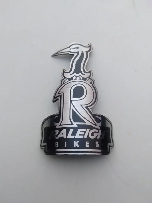 Raleigh bicycle head badge emblem in etched handmade stainless steel with silver and black Heron logo.