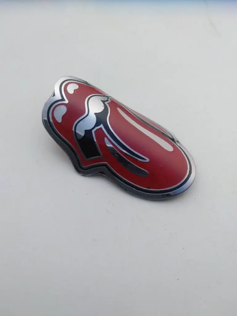 Side profile perspective showing the slim etched stainless steel construction of the Rolling Stone emblem.