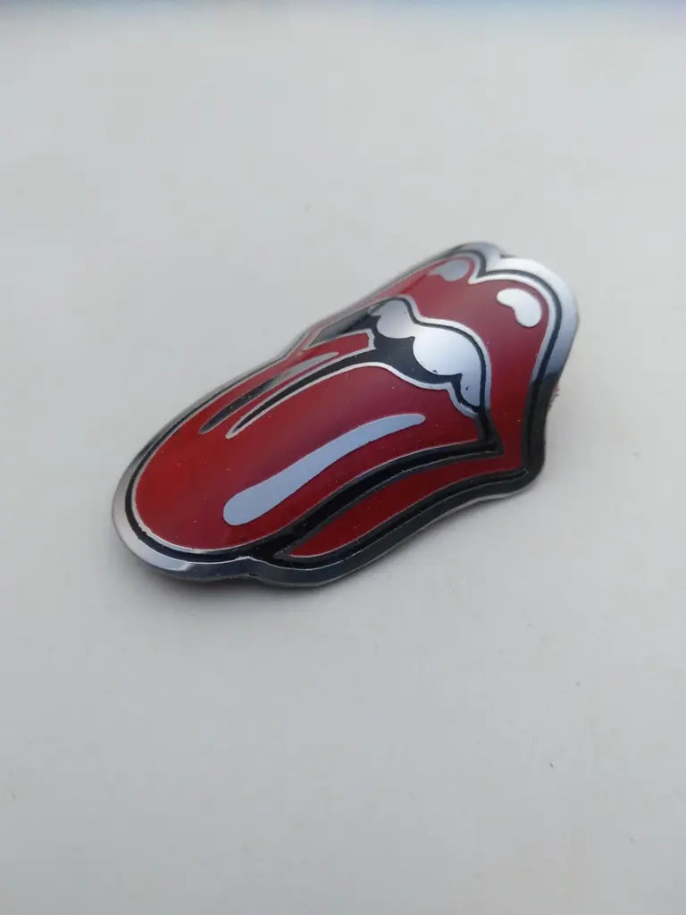 Detail shot highlighting the crisp etched line art and red paint infill on the Rolling Stone reproduction bike badge.