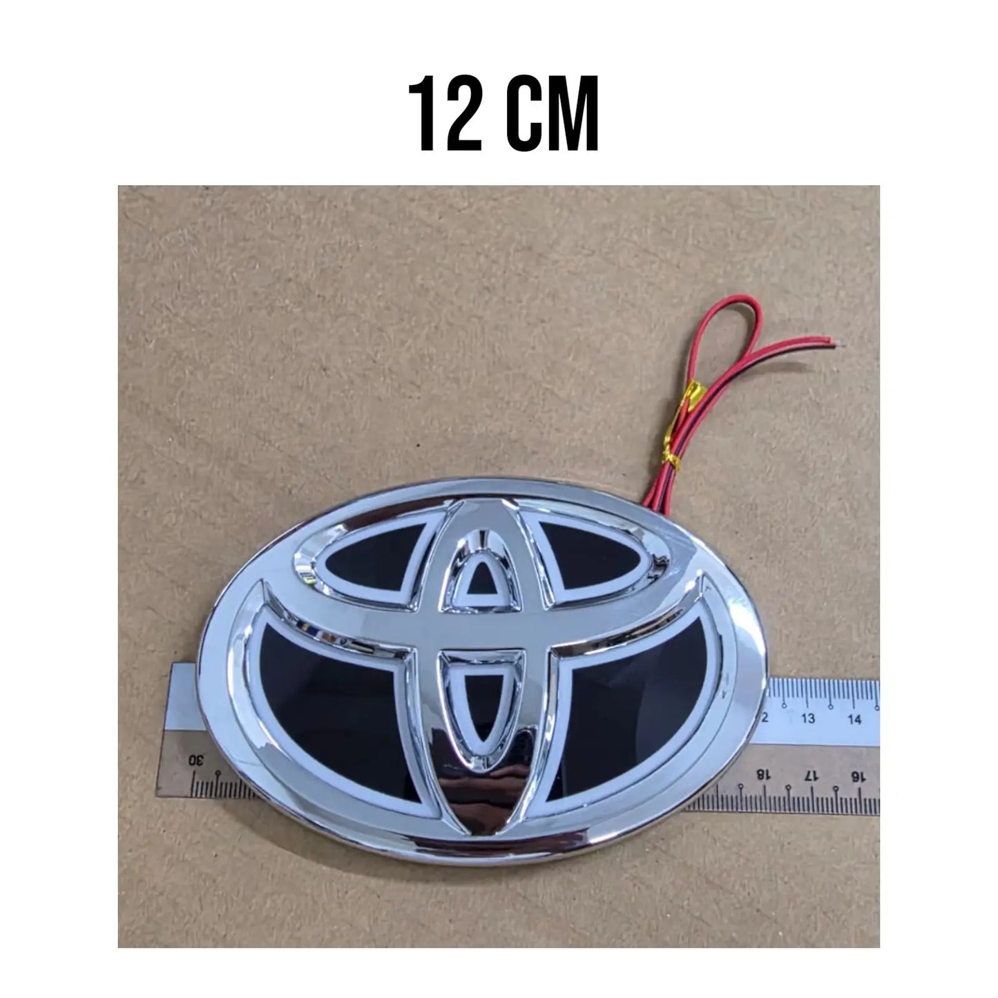 Detailed view of the 2-wire 12V positive and negative electrical leads on the Toyota blue LED badge.